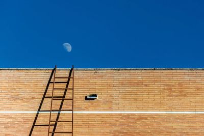 Low angle view of moon against clear blue sky