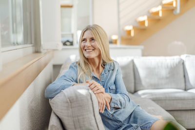 Smiling woman at home sitting on couch