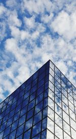 Low angle view of modern building against blue sky