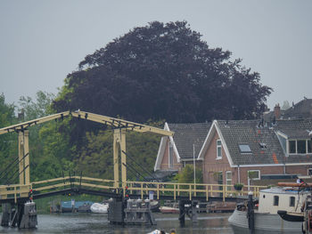 Bridge over river in city against sky