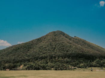 Scenic view of mountain against blue sky