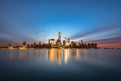 City at waterfront against cloudy sky