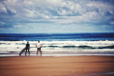 People on beach against sky