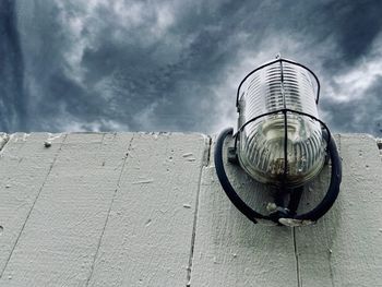 Low angle view of lamp against wall