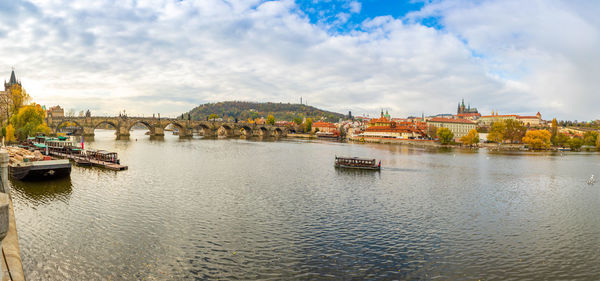 City at waterfront against cloudy sky