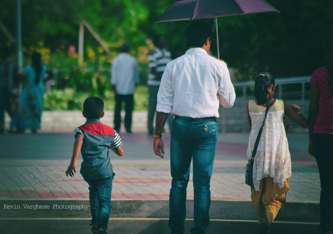 REAR VIEW OF FRIENDS WALKING ON FOOTPATH