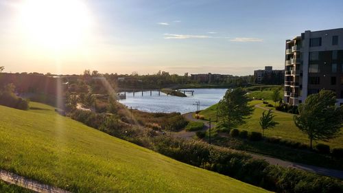 Sun shining over river in city