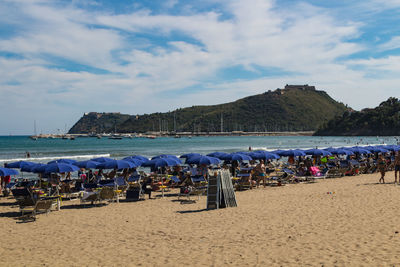 Group of people on beach against sky