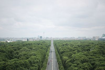 Road leading towards city against sky