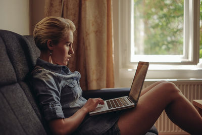 Woman using laptop on couch