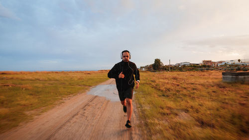 Man with headphone running outdoor during rain day