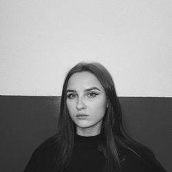 Portrait of a young woman against wall