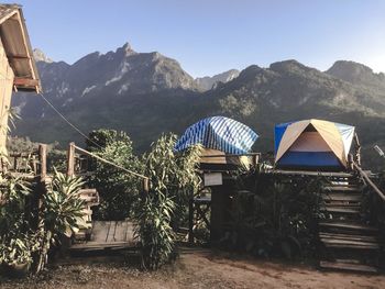 Built structure against trees and mountains against clear sky