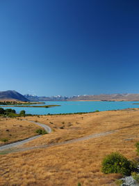 Scenic view of beach against clear blue sky