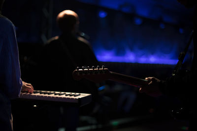 Midsection of man playing guitar