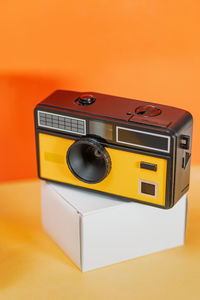 Close-up of camera on yellow background