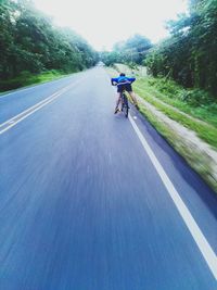 Man riding bicycle on road