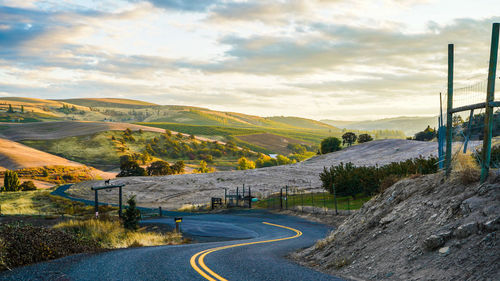 Road leading towards mountains against sky