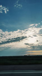 Scenic view of field against cloudy sky