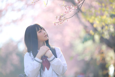 Woman standing on cherry blossom outdoors