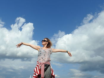 Low angle view of woman standing against sky