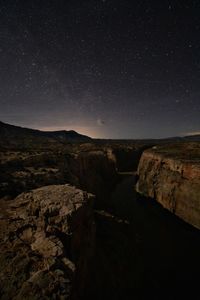 Scenic view of rocks at night against sky