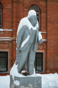 Statue against building during winter