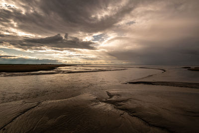 Scenic view of beach against sky during sunset