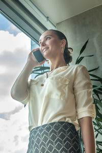 Low angle view of young woman looking away