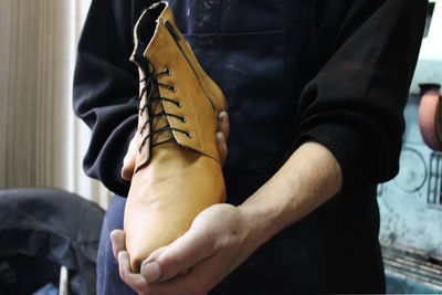 Midsection of woman holding shoe