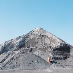 Man against mountain range against clear blue sky