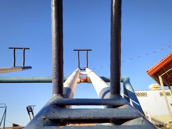 Low angle view of ladder against clear blue sky