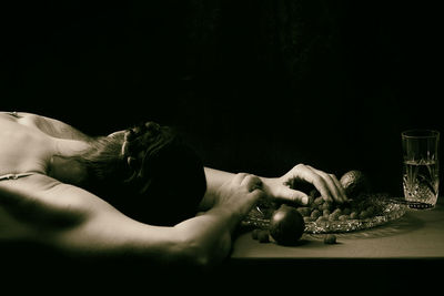 Woman offering a passion fruit between crystal crockery xi