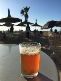 Close-up of beer on table at beach