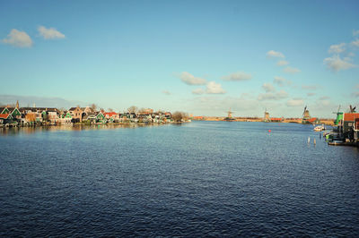 Sea by cityscape against sky