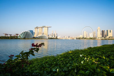 View of city at waterfront against clear sky