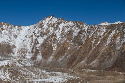 Scenic view of snowcapped mountains against clear blue sky