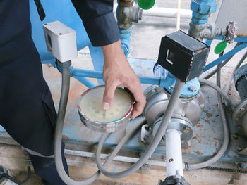 High angle view of man holding pressure gauge