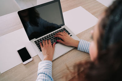 High angle view of people using laptop on table