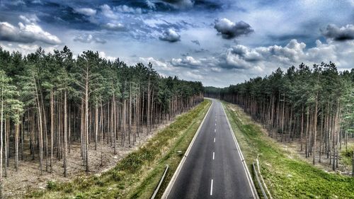 Empty road with trees in background