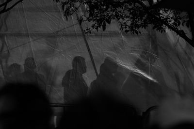 People seen through tent at night