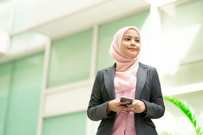 Full length of a young woman using phone