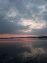 Scenic view of sea against dramatic sky during sunset