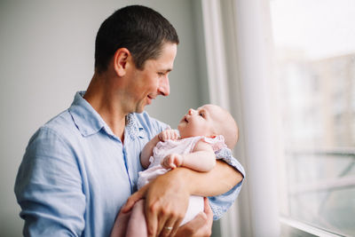 Fathers day holiday. middle age caucasian father hugging and kissing newborn baby. man parent 