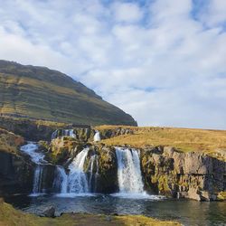 Scenic view of waterfall against sky