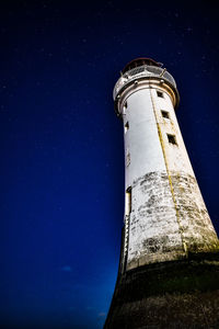 Low angle view of lighthouse against clear sky at night