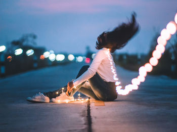 Rear view of woman in illuminated city at night