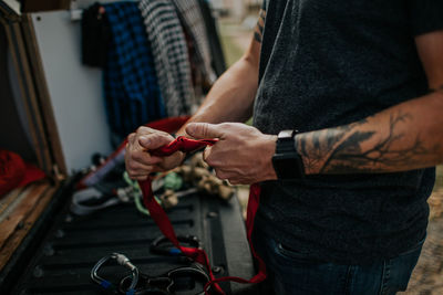 Man tightening knots on climbing ropes