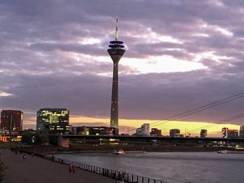 View of illuminated buildings against cloudy sky