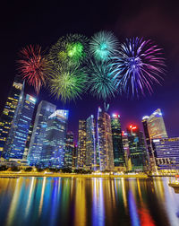 Firework display over illuminated buildings in city at night